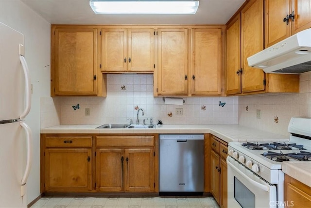 kitchen with white appliances, sink, and tasteful backsplash