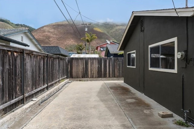 view of side of home featuring a mountain view and a patio