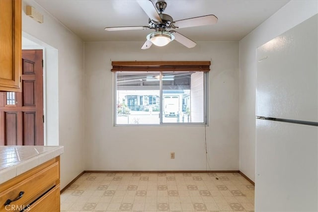 unfurnished dining area featuring ceiling fan