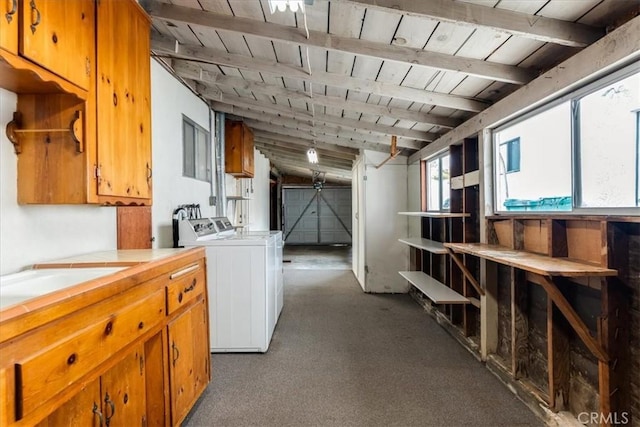 basement featuring sink, dark colored carpet, a barn door, wood ceiling, and washer and dryer