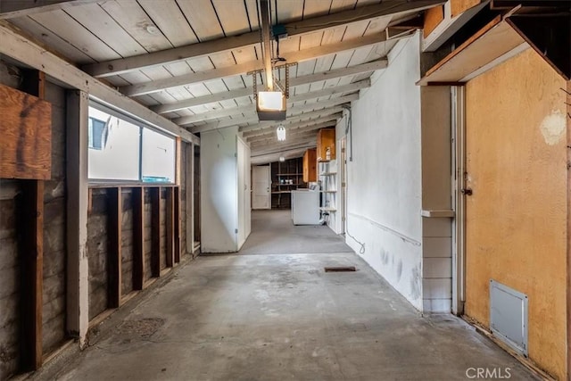 interior space with vaulted ceiling with beams, washer / clothes dryer, concrete floors, and wood ceiling