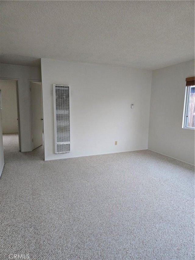 carpeted spare room featuring a textured ceiling