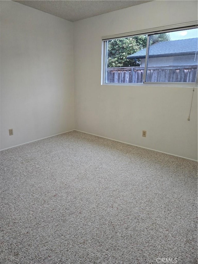 carpeted spare room with a textured ceiling