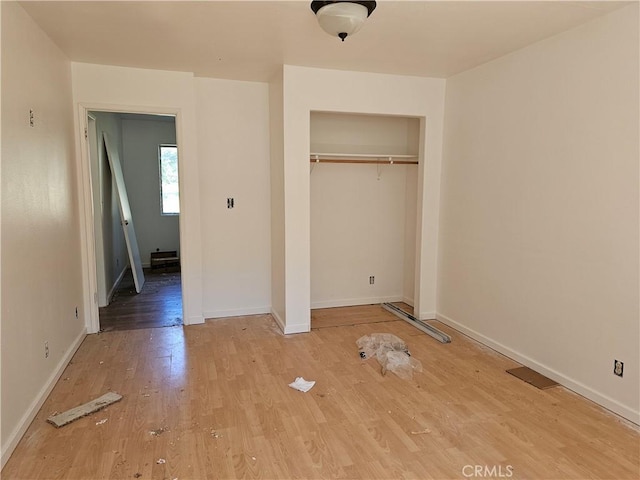 unfurnished bedroom with wood-type flooring and a closet