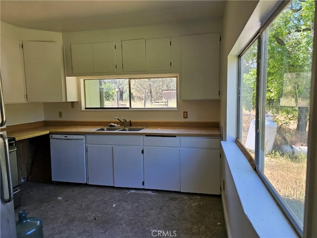 kitchen with white dishwasher, white cabinetry, and sink