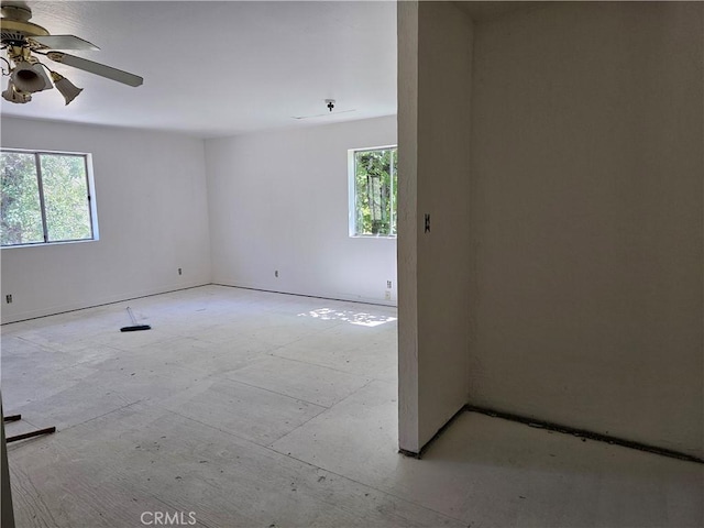 empty room with ceiling fan and plenty of natural light