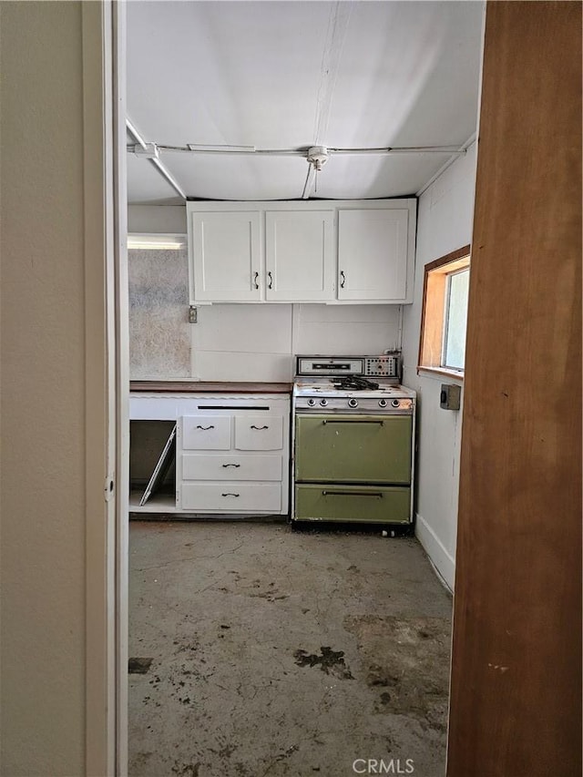 kitchen featuring white cabinets and white stove