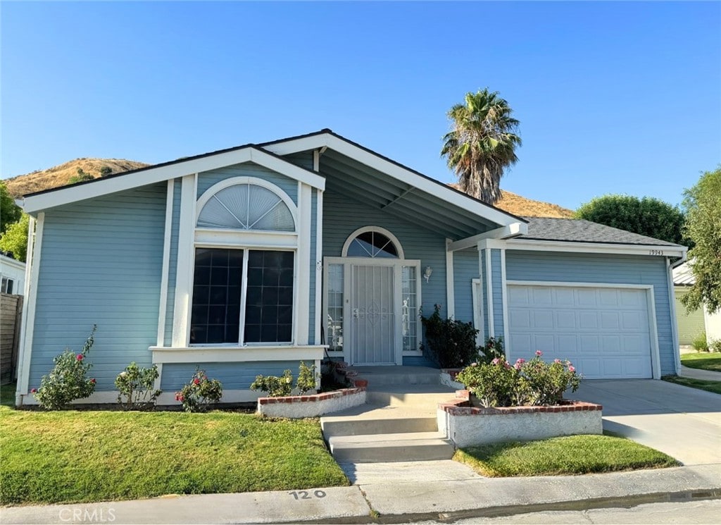 view of front facade with a garage, a front yard, and driveway