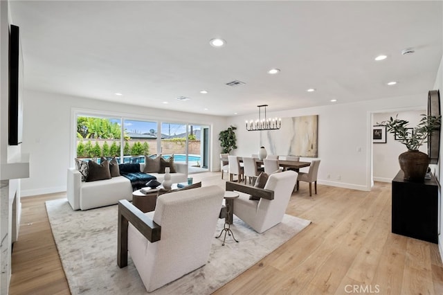 living room featuring light hardwood / wood-style floors and a notable chandelier