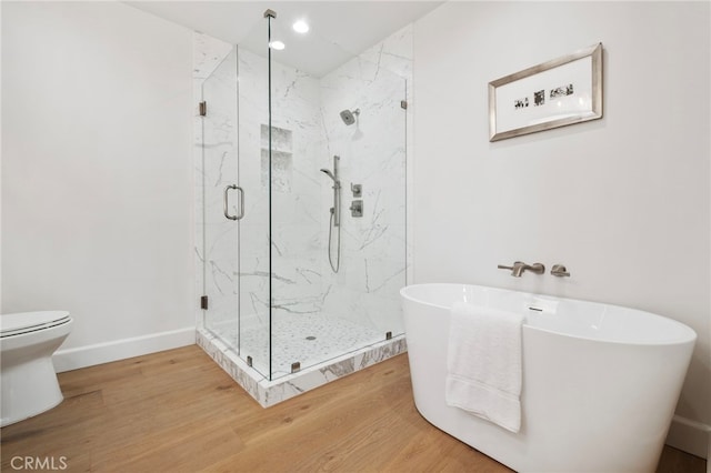 bathroom with toilet, wood-type flooring, and independent shower and bath