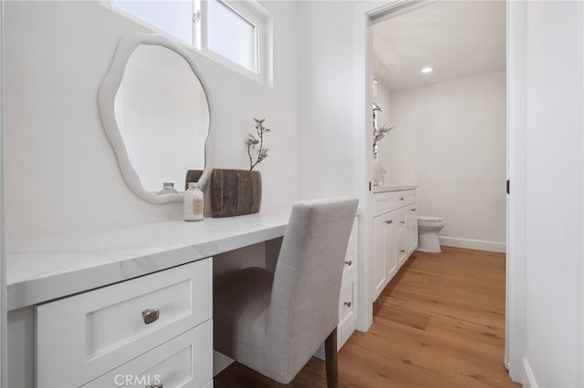 bathroom featuring wood-type flooring, vanity, and toilet