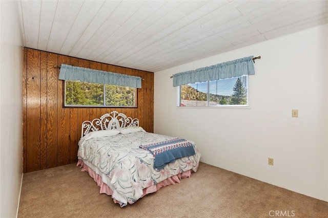 carpeted bedroom with wood walls