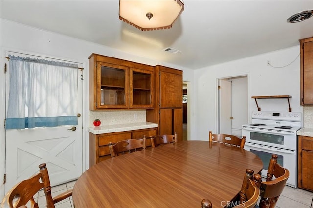 kitchen with tasteful backsplash, double oven range, and light tile patterned flooring