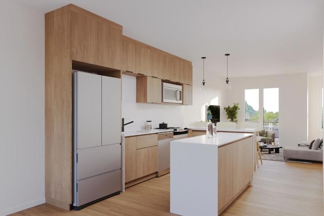 kitchen with light wood-type flooring, white appliances, hanging light fixtures, and light brown cabinetry