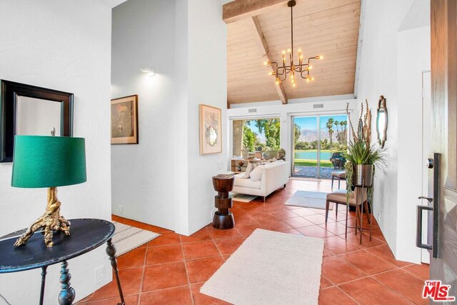 living room with wood ceiling, a notable chandelier, tile patterned flooring, high vaulted ceiling, and beam ceiling