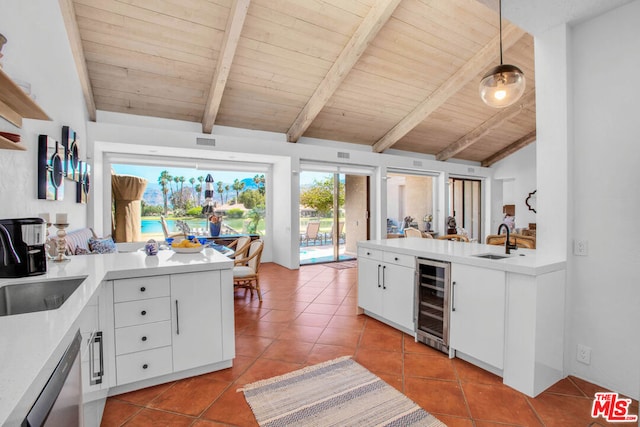 kitchen featuring decorative light fixtures, sink, white cabinets, beverage cooler, and wooden ceiling