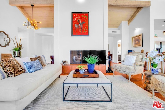 living room featuring vaulted ceiling with beams, tile patterned flooring, a notable chandelier, and wood ceiling