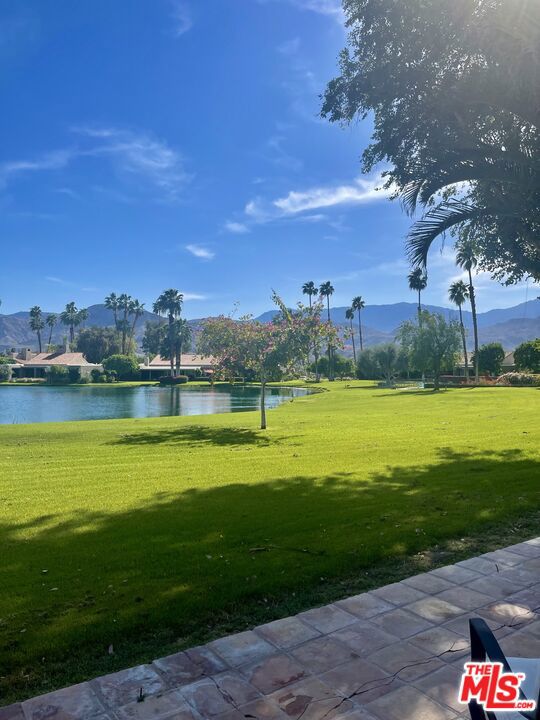 view of property's community featuring a lawn and a water and mountain view