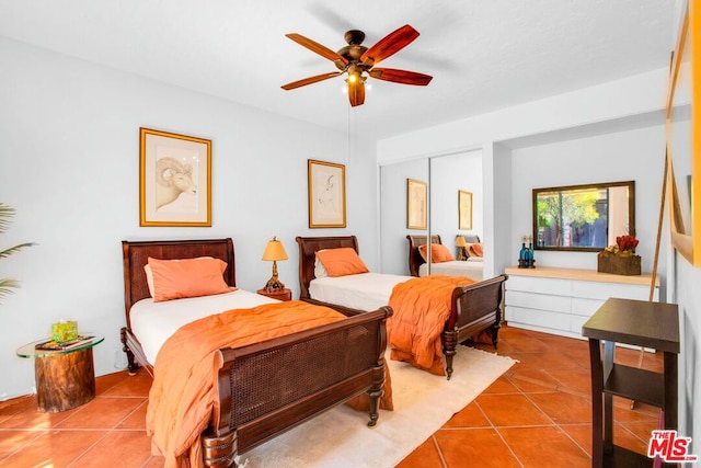 bedroom with ceiling fan, tile patterned flooring, and a closet