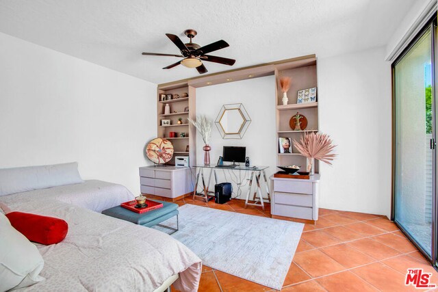 bedroom with ceiling fan, access to exterior, a textured ceiling, and light tile patterned floors