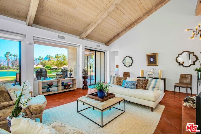 living room with wooden ceiling, dark tile patterned floors, beam ceiling, and a chandelier