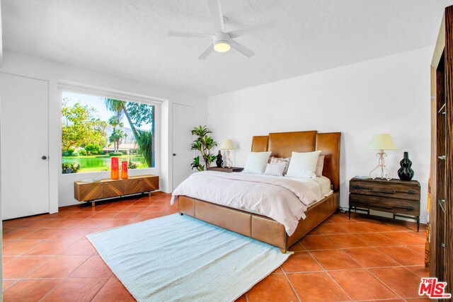 bedroom with ceiling fan and tile patterned flooring