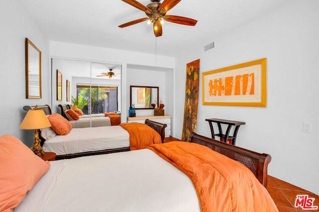 bedroom with ceiling fan and tile patterned flooring