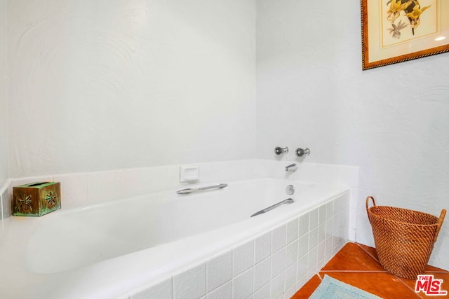 bathroom with tiled bath and tile patterned floors