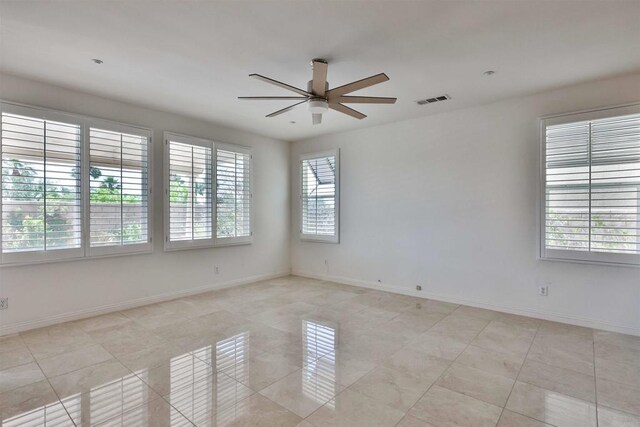 tiled spare room featuring ceiling fan and plenty of natural light