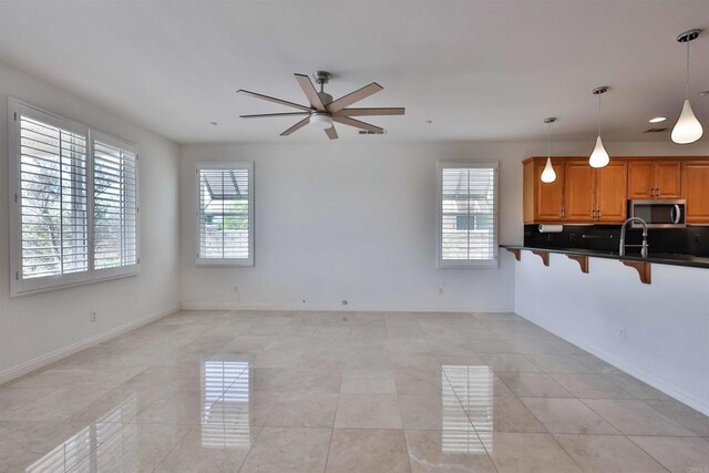 unfurnished living room with ceiling fan