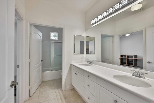 full bathroom with combined bath / shower with glass door, vanity, toilet, and tile patterned flooring