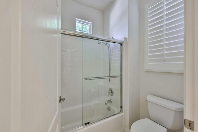 bathroom with enclosed tub / shower combo and toilet