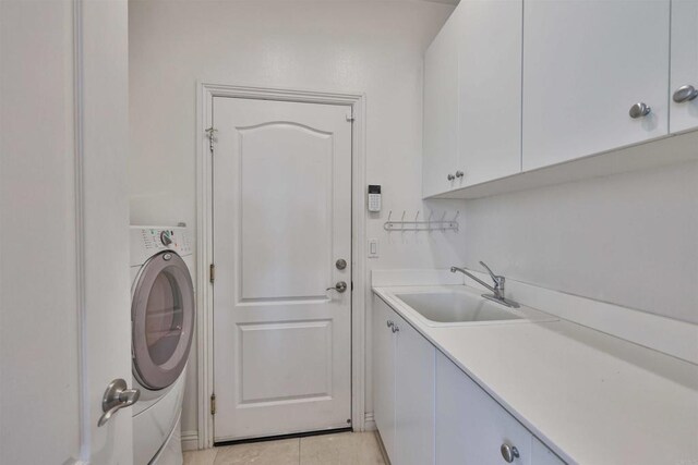 laundry area featuring cabinets, washer / clothes dryer, light tile patterned floors, and sink