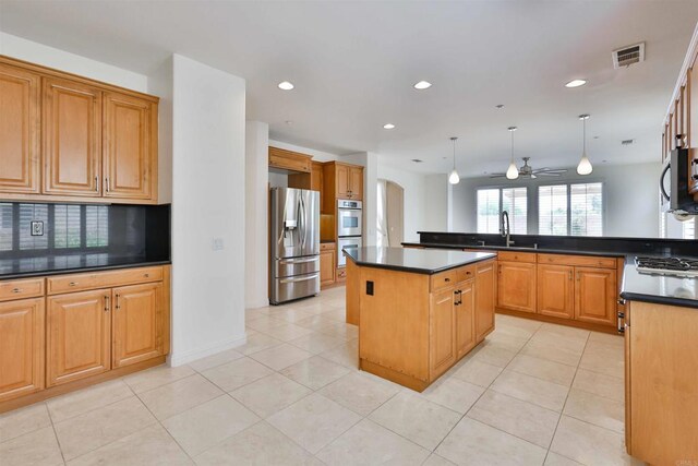 kitchen featuring pendant lighting, a center island, sink, appliances with stainless steel finishes, and ceiling fan