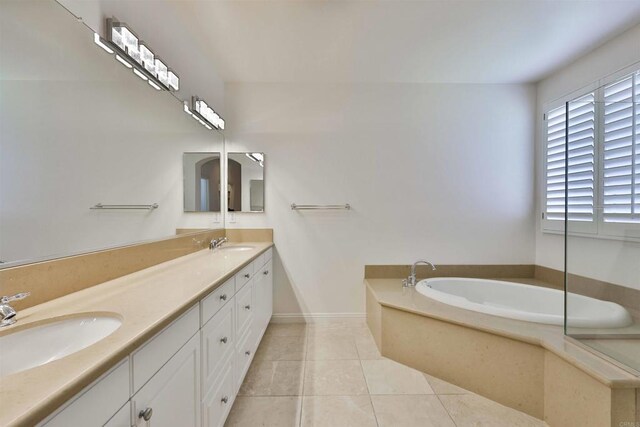 bathroom with tile patterned flooring, a bath, and vanity