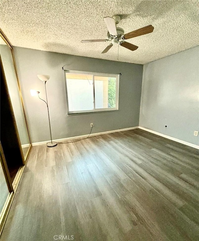 unfurnished bedroom with ceiling fan, dark hardwood / wood-style floors, and a textured ceiling