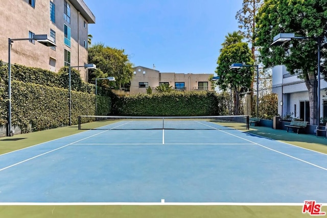 view of tennis court with basketball hoop