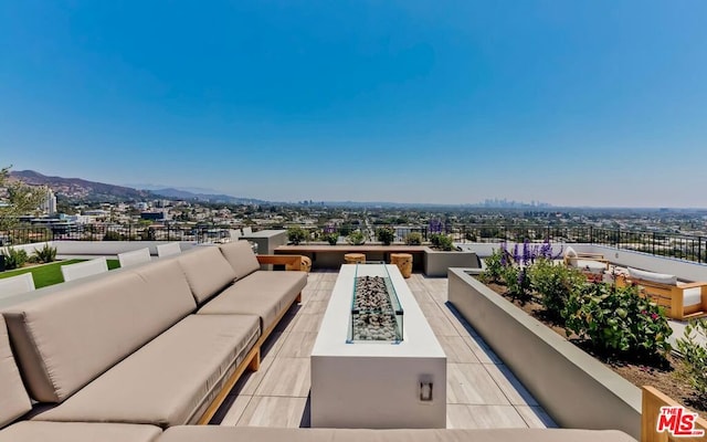 view of patio / terrace featuring a mountain view and an outdoor living space with a fire pit