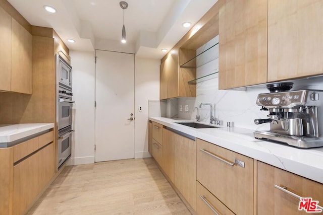 kitchen featuring light brown cabinetry, sink, appliances with stainless steel finishes, and light hardwood / wood-style flooring