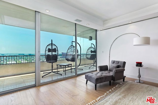 living area featuring a wall of windows and wood-type flooring