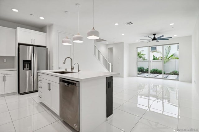 kitchen featuring stainless steel appliances, ceiling fan, sink, pendant lighting, and white cabinets