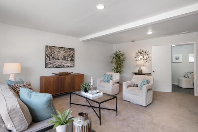 carpeted living room featuring beam ceiling