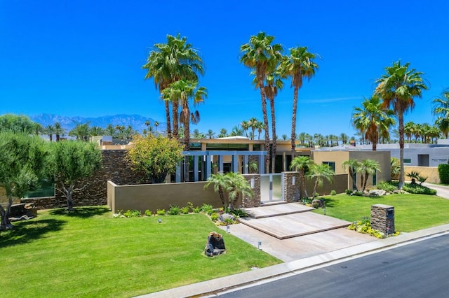 view of front of house featuring a mountain view and a front lawn