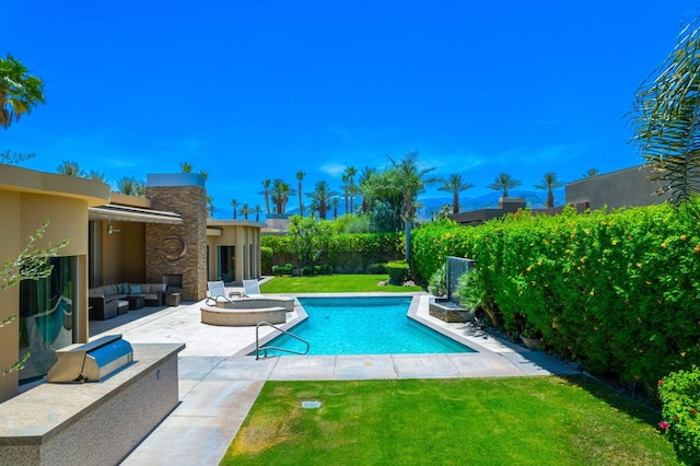 view of swimming pool with a patio, an outdoor living space with a fire pit, and a lawn