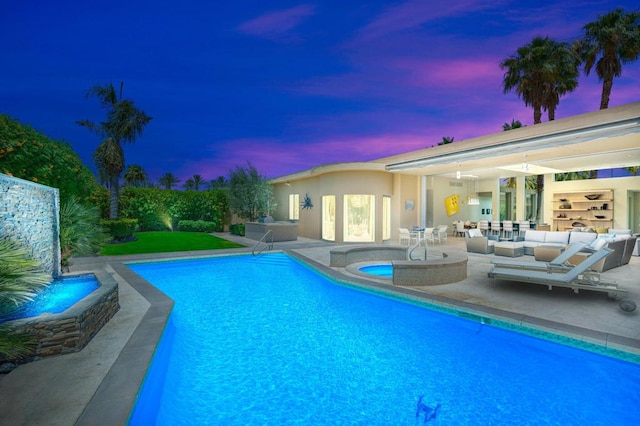 pool at dusk featuring a patio, ceiling fan, and an outdoor hangout area