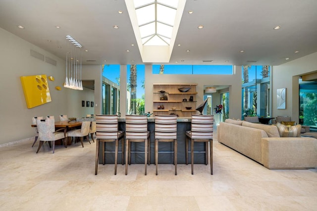 kitchen with a skylight, a kitchen bar, and a wealth of natural light