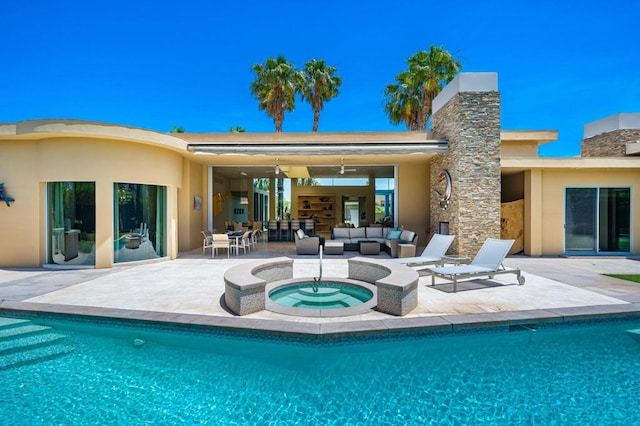 rear view of house with outdoor lounge area, a swimming pool with hot tub, and a patio area