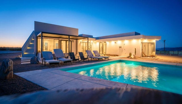 pool at dusk featuring a patio area