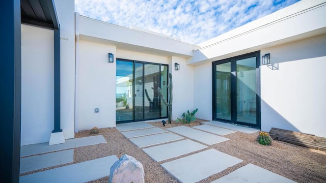 view of exterior entry with a patio area