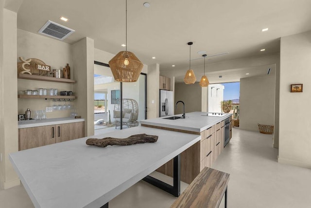 kitchen with sink, a spacious island, stainless steel appliances, and hanging light fixtures